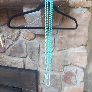 Turquoise colored "pearl" neclace. Very long.